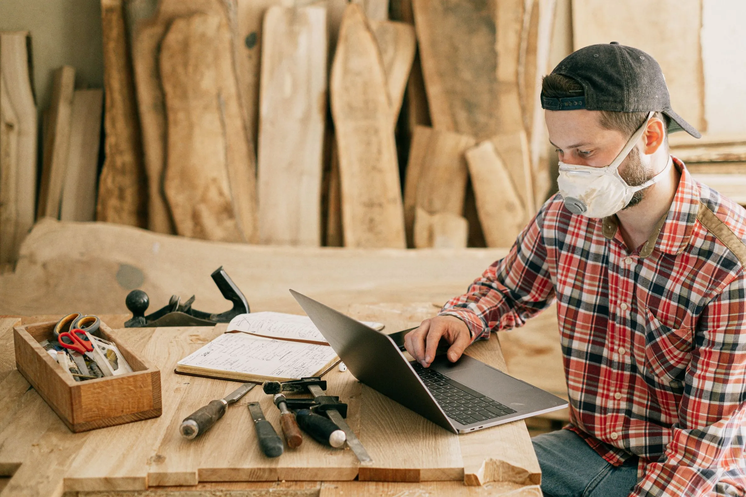 Un artisan travaille sur un ordinateur portable dans son atelier